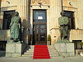 Entrance in the building with statues of two Krajina peasants