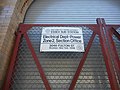 Sign on the gate in front of the aluminum roll-up door. This powerhouse is also known as the "Essex Sub-Station."