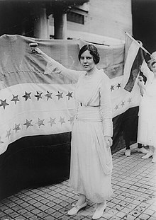 Alice Paul stands before the Woman Suffrage Amendment's ratification banner.