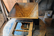 A wooden hopper for grain, on a millstone Anselma Hopper.jpg