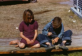 Arthur Rothstein, Boy building a model airplane as girl watches, FSA camp, Robstown, Texas, 1942.jpg