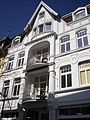 Facade of a residential and commercial building with half-timbered gable, loggias and Art Nouveau decor