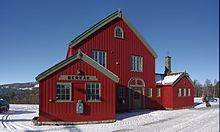 Foto eines rot gestrichenen Bahnhofgebäudes im Schnee