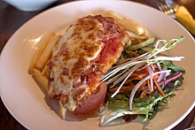 Chicken parmigiana with chips and salad, a common serving in Australia Chicken parmigiana.jpg