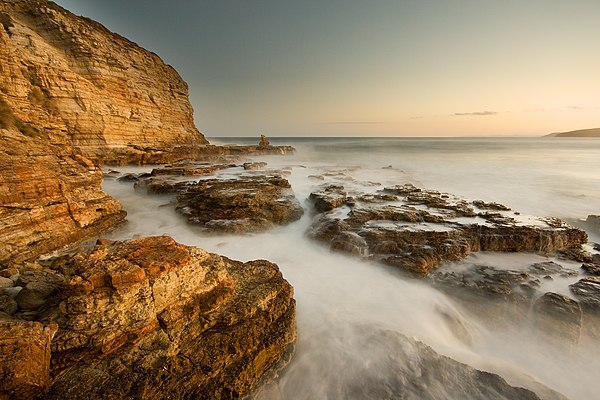A seascape photograph at Clifton Beach, South Arm, Tasmania, Australia. The white balance has been adjusted towards the warm side for creative effect.