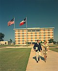 Couple walking in front of University of Texas at Arlington's new six-floor Library, 1967