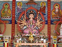 Cundi, flanked by devas, and with Bhaisajyaguru Buddha (left) and Amitabha Buddha (right). The Chinese text on the front of the altar reads, Namo Zhunti Wang Pusa, or "Namo Cundi King Bodhisattva." Statue located at a Chinese Buddhist temple in Kelantan, Malaysia.