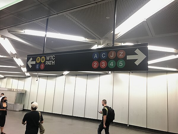 Signs in the Fulton Center (like this one) only show the E, R and W train symbols when pointing toward the Chambers Street/World Trade Center station,