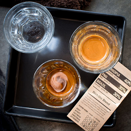 A double ristretto with the first half of the shot in the glass at the bottom of the image, and the second half in the glass on the right