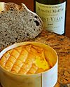 A typically runny piece of Époisses cheese with some bread and Burgundy wine