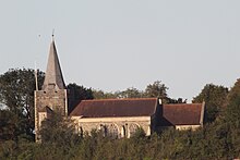 Eine Kirche mit Turm und Turmspitze, umgeben von Bäumen