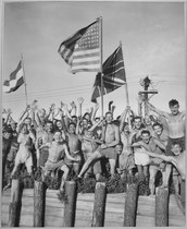 Allied prisoners of war at Aomori camp near Yokohama, Japan, waving flags of the United States, Great Britain, and the Netherlands in August 1945