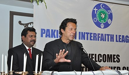 Khan addressing an Interfaith Christmas Dinner in 2014