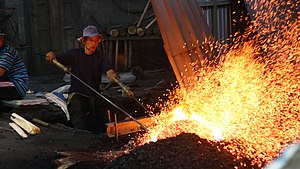 Pande (Gamelan Maker) is burning Gong in Besalen in Central Java, Indonesia Javanese Gamelan Burning Gong.jpg