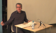 Mark Fisher lecturing on the topic "The Slow Cancellation of the Future" in 2014 Mark Fisher Slow Cancellation.png