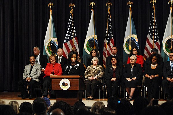 First Lady Michelle Obama and Secretary of the Interior Ken Salazar, joined by some of the department's longest-serving employees on stage, thanked al