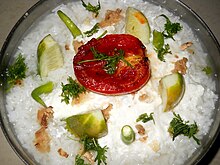 Pakhala served with wads of lemon, yoghurt and a slice of tomato. Odisha pakhala.jpg