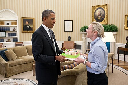 President Barack Obama presents a birthday cake to Personal Secretary Anita Decker in the Oval Office.jpg
