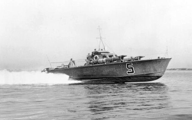 Royal Navy World War II MTB planing at speed on calm water showing its hard chine hull with most of the forepart of the boat out of the water.