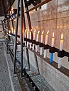 Candelabros colocados a la izquierda de la virgen junto a diversas velas que llevan de oraciones puestas por creyentes en 2021.