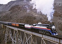 SP 4449 leads an excursion train through the Deschutes River canyon at Trout Creek, Oregon, on March 23, 2002, while bearing the colors of the American Freedom Train. Trout Creek (12690798).jpg