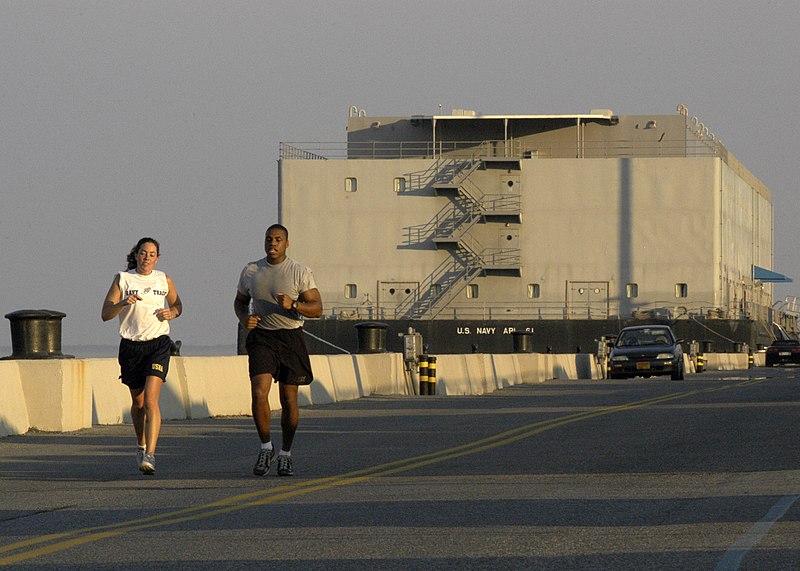 File:US Navy 031009-N-9693M-001 Mid'n 1st Class Shannon Revell and Cadet 2nd Class Wrendon Hunt, an exchange student from West Point, jog past the U.S. Navy Barracks Craft Auxiliary Personnel Lighter Sixty One (APL-61) moored along.jpg