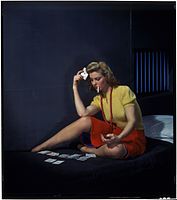 Woman in cell, playing solitaire, ca. 1950.