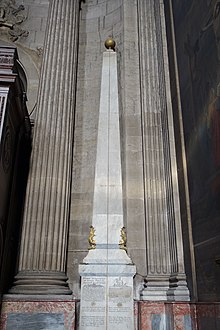 Kleurenfoto van een pilaar met daarboven een metalen bal.