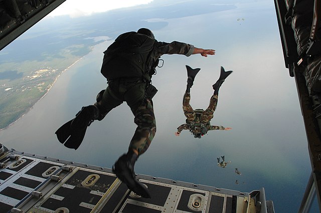 United States Air Force paratroopers from the 720th Special Tactics Group jumping from a C-130J Hercules aircraft during water rescue training off the