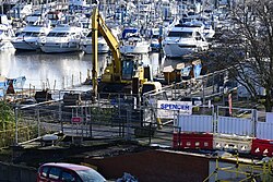 An excavator on one of many barges in Hull Marina laying in wait for excavation work for the future site of the Spurn Lightship, photographed from the top of the Princes Quay multistorey car park.