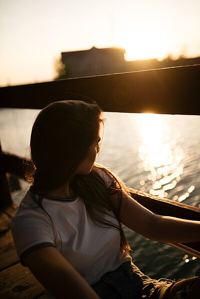File:Beautiful girl enjoying on terrace near lake with sunset in background.jpg