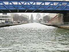 Le canal de l'Ourcq à Pantin. Au fond, la silhouette des Grands Moulins de Pantin.