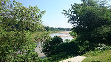 Dhalai River behind trees Dhalai River behind tree.jpg