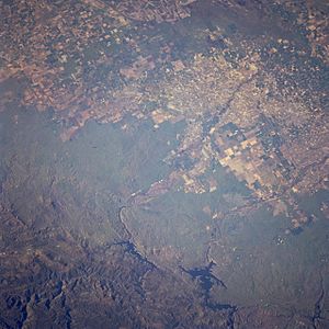 Overhead view of Don Pedro Reservoir (bottom/east center−right), upstream of irrigated fields in the San Joaquin Valley (top/west)