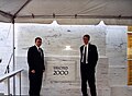 Two LDS missionaries stand in front of the cornerstone