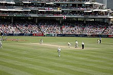A Test match between South Africa and England in January 2005. The men wearing black trousers are the umpires. Teams in Test cricket, first-class cricket and club cricket wear traditional white uniforms and use red cricket balls. England vs South Africa.jpg