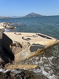 Face on a concrete block at a beach in Greece