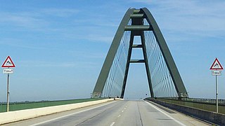 Fehmarnsund brug dichtbij in de lengteas. In gebruik als verkeersbrug, spoorbrug en met voetpad