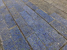 The tiles have rapidly faded to a blue-grey colour, a fact that is made more obvious when damaged tiles are replaced with those of the original colour. Hancock Blue Carpet 4348.JPG