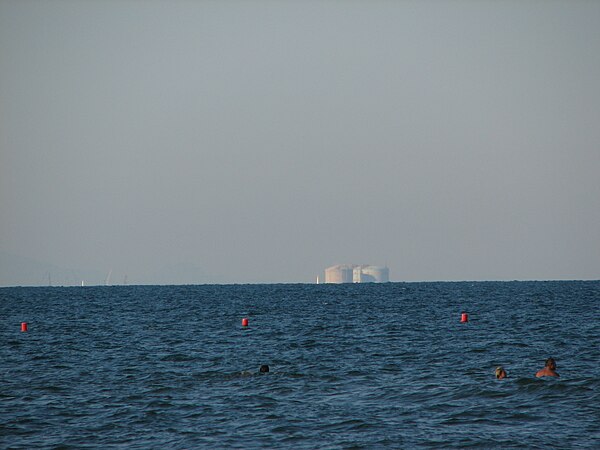 A view across a 20-km-wide bay in the coast of Spain. The curvature of the Earth is evident in the horizon across the image, and the bases of the buil