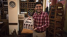 Ibrahim Dogus with a sample of his beer for drinking with kebabs at Troia restaurant, Waterloo Ibrahim Dogus Bira.jpg