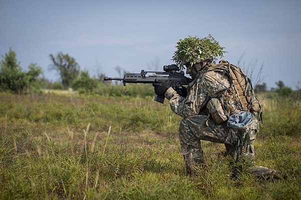 A soldier from the Latvian National Guard's 2nd Brigade, 25th Infantry Battalion aims at targets during tactical training at the Camp Grayling Joint M