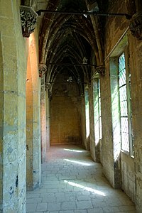 Salle vide plus longue que large, sous des voûtes de pierre