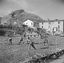 Gunners of the Surrey & Sussex Yeomanry play an impromptu game of cricket in front of their Priest SP guns in Italy. Sport and Leisure in the British Army during the Second World War NA20484.jpg