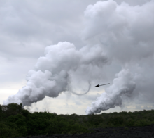 Figure 3. Steam devil at Big Island, Hawaii. The large plumes of vapour are caused by lava entering the ocean. Steam devil Hawaii arrow.png