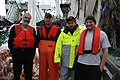 Trawl fishermen wearing brightly colored personal flotation devices to protect against drowning.