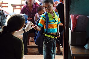 US Navy 080817-N-4515N-083 Canadian Army Capt. Kim Templeton, a medical augmentee embarked aboard the amphibious assault ship USS Kearsarge (LHD 3), gives a young boy a rainbow sticker.jpg