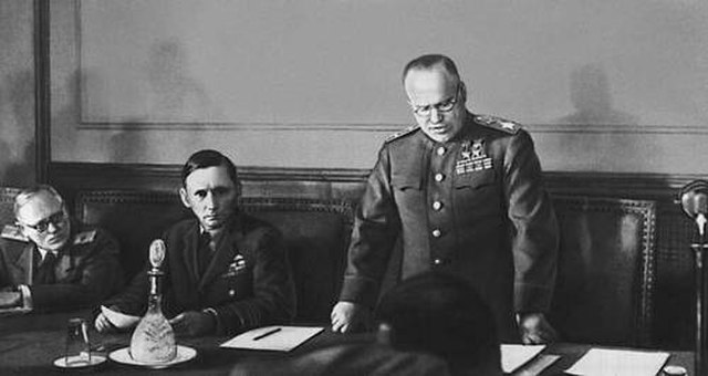 Marshal Zhukov reading the German capitulation. Seated on his right is Air Chief Marshal Arthur Tedder.