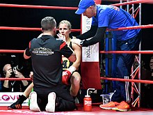 Boxer Tina Rupprecht receiving instructions from her trainer while being treated by her cutman in the ring corner between rounds. 2017-12-02 Tina Rupprecht - Anne Sophie Da Costa - DSC2771.jpg