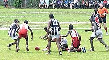 Action from the 2005 TIFL Grand Final between Pumarali (red and white) and Muluwurri (black and white). Aboriginal football.jpg